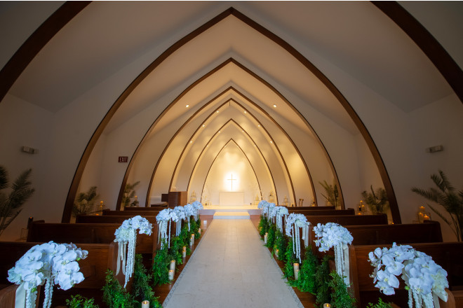 白を基調とした気品あふれる佇まいの独立型チャペル。24年チャペル内装花をリニューアル。胡蝶蘭を基調にしたピューフラワーは、ナチュラルな中にも高級感のある雰囲気に。