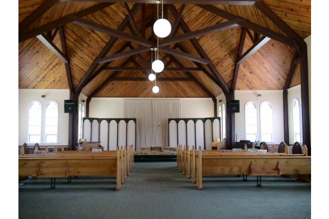 木の温もりに満ち、前後左右にクロスしたバージンロードが個性的な教会