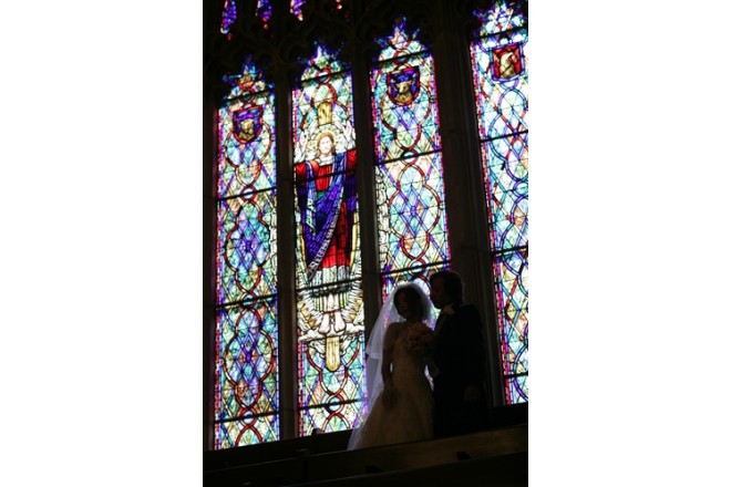 挙式後の撮影。ステンドグラスがロマンチックに2人を演出