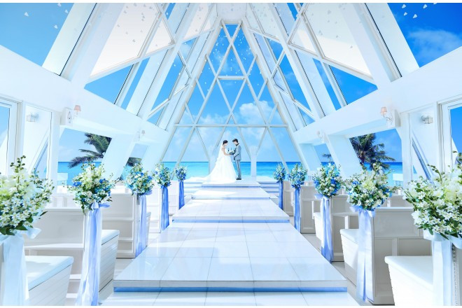 青く澄みわたる空と遥かに広がる海が溶け合う奇跡のような 美しいブルーに浮かぶ、全方向ガラス張りのチャペル。