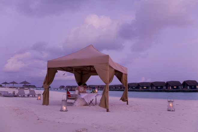 キャンドルの揺らめく光の中で渚のウエディングディナー。