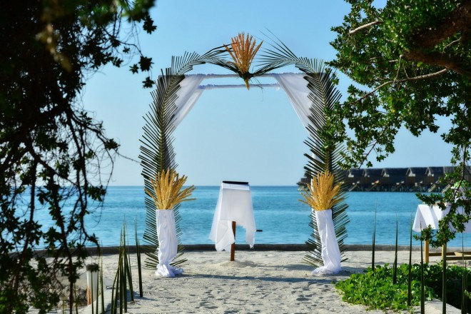 緑のアーチの先に広がるモルディブのブルーを眺めながらのウェディング