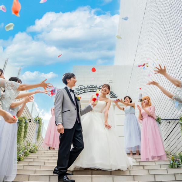 挙式後のセレモニー、フラワーシャワーとクラッカーで祝福される新郎新婦