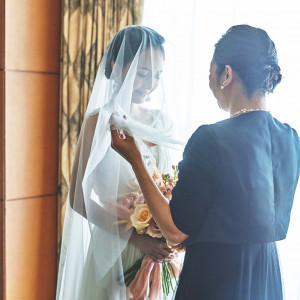 今までそばで見守ってきたご家族によるベールダウンは、花嫁支度の結びとなる感動的なシーンです。|横浜ベイホテル東急の写真(29459900)