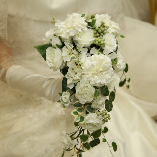 ウエディングドレスのデザインに合わせた、生花のホワイトブーケ。