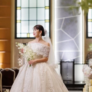 開放的なアトリウムウエディングや壮大なメインホールにも映える、クラシカルなデザインのウエディングドレス。ホテルらしい上質さと繊細なレースで洗練された花嫁に。