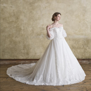 オフショルダーのデザインがデコルテラインを美しく際立たせ、ふんわりとしたパフスリープがは花嫁様の可憐さを。スパンコール煌めくラッセルレースでラグジュアリーな雰囲気に。|グランドニッコー東京 台場の写真(53887067)