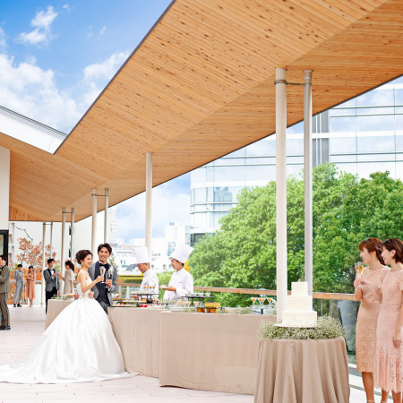 開放的なテラスで行われるウェルカムパーティーでゲストとの歓談を楽しむ