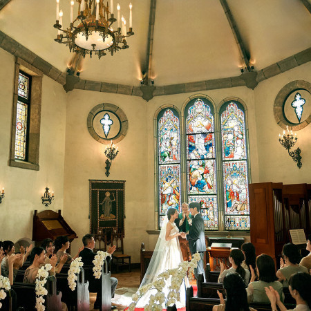 ステドグラスを背景に誓いを交わす瞬間