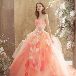 ドレスにあしらわれた花々は立体的で動きが出るように仕上げられている。目を引く鮮やかなカラーのコーラルオレンジがロマンティックで お顔周りを華やかに明るく見せてくれる1着！