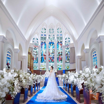 120年の歴史を漂わせる本格ステンドグラスに包まれる中、誓いを立てる挙式