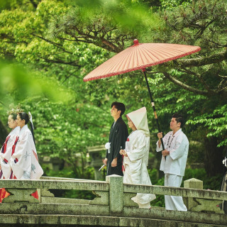 朱傘と白無垢、そして境内の緑が美しいコントラストを織りなす