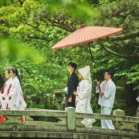 朱傘と白無垢、そして境内の緑が美しいコントラストを織りなす