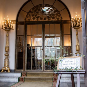 メインエントランス 建てられた当時からの真鍮の扉。お二人らしいウェルカムボードを飾って。|小笠原伯爵邸の写真(7259780)