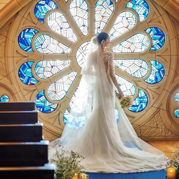 純白のウェディングドレスが映える青いステンドグラス