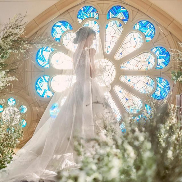 純白のウェディングドレスが映える青いステンドグラス