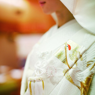 格式高い白無垢。やさしい風合いのちりめん生地に羽ばたく鶴と桜を刺繍で贅沢に表現。