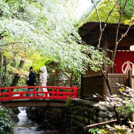 自然豊かな緑が広がる庭園にかかる朱色の橋
