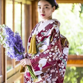 様々な花が鮮やかに彩られたモダンな色打掛 ゴールドの小物で印象深く