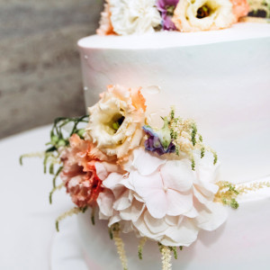 注目のケーキ入刀シーン！テーブル装花とウェディングケーキのフラワーをお揃いにすると統一感アップ↑真っ白なウェディングケーキにお花をのせるのはオリジナル感もあってオススメ★|mitte(ミッテ)の写真(6770585)