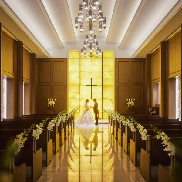 7mの天井高。イエローオニキスが温かな明かりを放つ圧巻の光壁は、ふたりのシルエットを美しく映します。