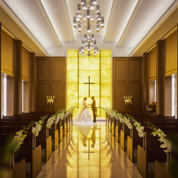 7mの天井高。イエローオニキスが温かな明かりを放つ圧巻の光壁は、ふたりのシルエットを美しく映します。