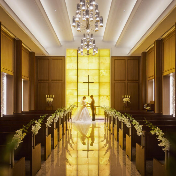 7mの天井高。イエローオニキスが温かな明かりを放つ圧巻の光壁は、ふたりのシルエットを美しく映します。