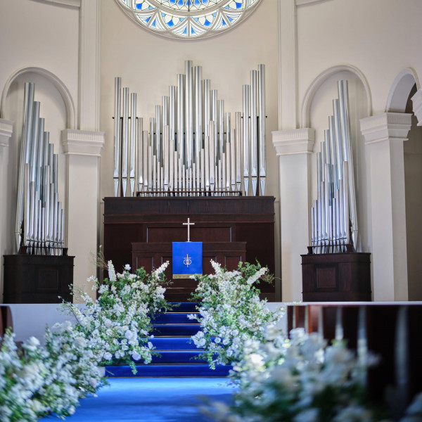 ロイヤルブルーのバージンロードが純白のウェディングドレスを引き立てる*