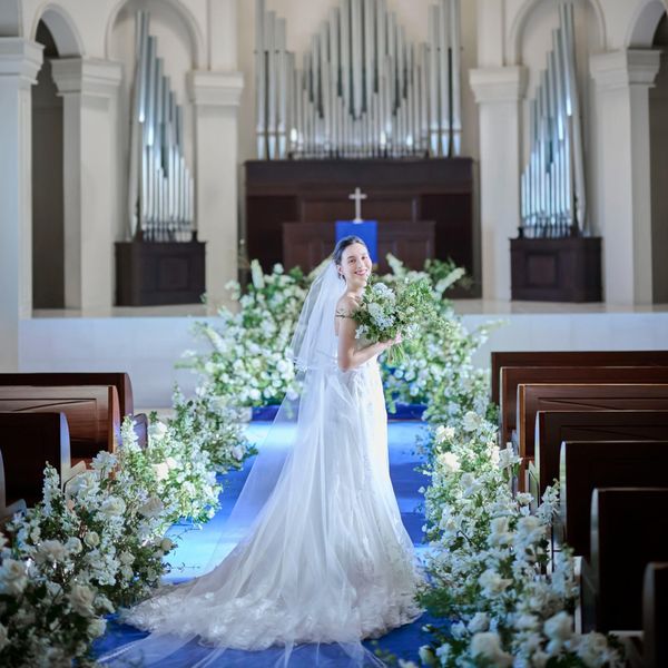 ロイヤルブルーのバージンロードが純白のウェディングドレスを引き立てる*