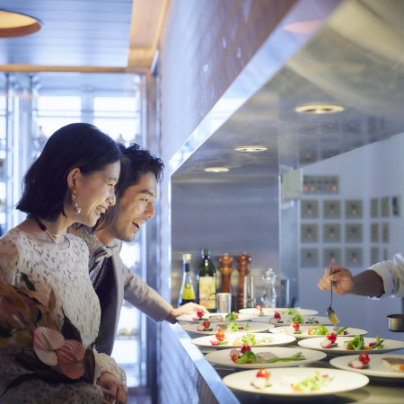 オープンキッチンから出来立てのお料理をお届け。臨場感が味わえ、ゲストのワクワクも増幅させる。