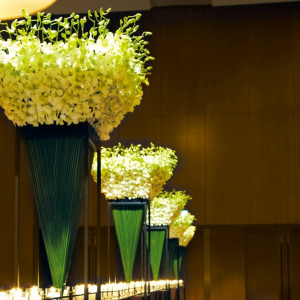 【装花】整然と並べられたキャンドルと背の高いフラワーアレンジメント。天井が高いバンケットによく映えるデザイン|コンラッド東京の写真(246369)