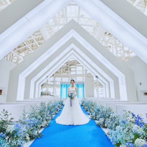 天高18mから陽光降り注ぐ開放的なチャペル。ロイヤルブルーのバージンロードがは花嫁を一層輝かせる。|ルミアモーレ（目黒雅叙園グループ）の写真(23749233)