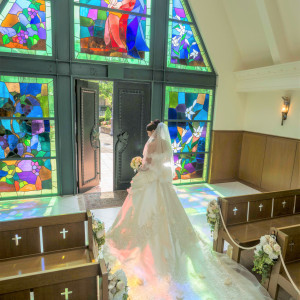 午前の結婚式は、太陽光がステンドグラスをバージンロードに映す幻想的な空間となる。本格派もカジュアル派も、ゲストの心に残る景色の中で挙式を。|ブライダルフォートの写真(27248316)