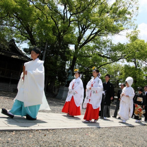 【参進の儀】神職・巫女に先導され、新郎新婦と参列者が神殿まで進んでいきます。気持ちを厳粛に整えるために重要な儀式。|川原神社（produce by ウエディングマルシェ）の写真(252430)