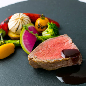 【信州牛フィレ肉のロティ 旬の夏野菜グリエと濃厚な赤ワインソース】信州牛のローストと、炭火で焼いた旬野菜。素材の力強い味わいが石皿の上で調和する贅沢なメインディッシュ|アネーリ軽井沢の写真(53063157)
