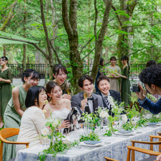 木漏れ日の下、ゲストと囲むパーティーテーブル。会話と笑顔が弾む和やかな時間