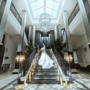 ロングトレーンが優雅にたなびく全天候型テラスの大階段。ここでは佇むだけで絵になりヒロイン気分を満喫できる人気のスポット|Wedding of Legend GLASTONIA  - グラストニア -の写真(39062642)