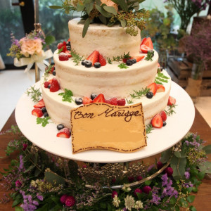 あえてクリームをラフに塗って仕上げたケーキ。添えられたケーキテーブルのお花、トップに乗せているお花とグリーンが、ケーキのナチュラルな雰囲気をより引き立てています＊|アルコラッジョ(arcoraggio) マリエールの写真(1589196)