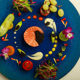 まるで芸術品。鮮やかな青い皿に描かれた、華やかで美しい至福の一皿。ソースまでこだわる逸品。