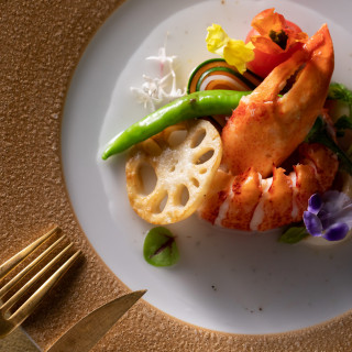ハレの日を飾るオマール海老を使用した豪華な一皿。 色彩豊かな食材が織りなす至福のフレンチ。
