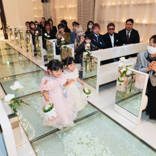 花びらが輝くガラスのバージンロード。小さなお子様も活躍し、ゲストの笑顔があふれる挙式です。
