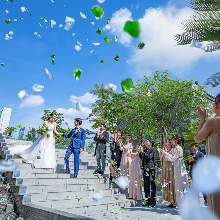 抜けるような青空の下、ゲストからのフラワーシャワーに祝福され、お二人の幸せに満ちた笑顔が最幸に輝く、思い出に残る感動的なワンシーンです。石造りの貸切邸宅だから叶う演出です