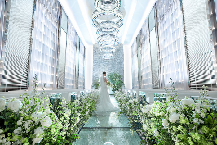 煌めくシャンデリアと、足元に広がるガラスのバージンロード。光と緑が創り出す幻想的なチャペル