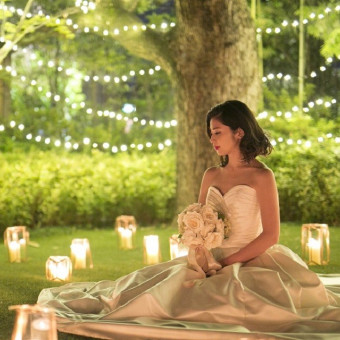夕刻のウエディングに映えるガーデンキャンドル。ロマンチックな瞬間が、花嫁を一際輝かせる