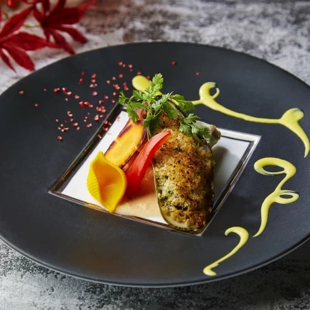 鯛に白身魚のムースとキノコを合わせて蒸しあげたものにパーナ貝のパン粉焼きを添えて