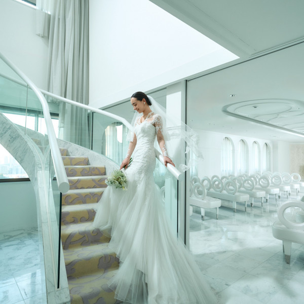 天空を彷彿とさせる純白のチャペル「ザ・スカイ」螺旋階段から登場する新婦、光に包まれた神秘的なシーンに