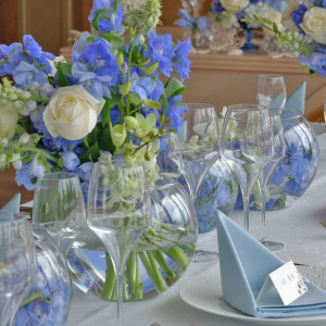 爽やかな青いお花をふんだんに使用したデザイン。パーティー会場からは海も見えるので、外の景色との相性もぴったり。メインテーブルにはお花の横に貝殻を並べて沖縄の海をイメージ。|ヴォヤージュ ドゥ ルミエール北谷リゾートの写真(35763059)