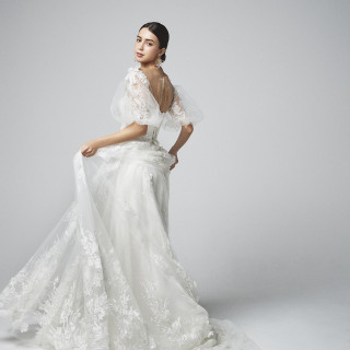 ドレス全体に施されたレースモチーフがロマンティック。花嫁をより美しくみせるパフスリーブで立体感を。