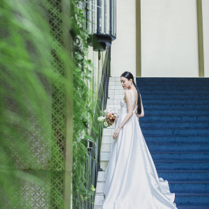 青い絨毯が印象的な大階段にウエディングドレスのトレーンの流れる様子が美しい一枚。|インフィニート 名古屋＜エルフラットグループ＞の写真(33649278)