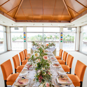 自然光をふんだんに取り入れた開放感のある空間には、華やかなテーブル装花がよく映える。|アイネス ヴィラノッツェ in カヌチャベイ～グラン・ブルーチャペル～/クチュールナオコウエディングの写真(2589138)